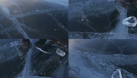 戴手套的人在冰上拧冰。缓慢的运动。镜头移到了冰的后面。一块美丽的冰在冰上旋转，有神奇的裂缝。高清在线视频素材下载