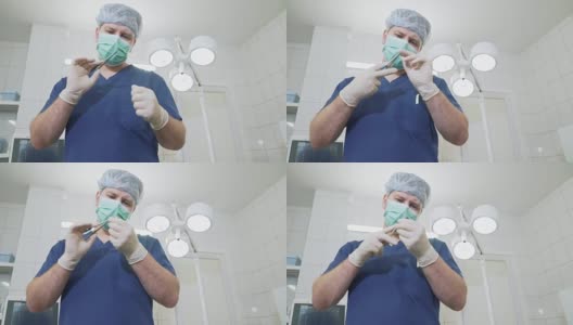 医生戴着无菌白手套和口罩在医院检查医疗器械。在诊所里，身着职业装的外科医生正在检查手上的夹高清在线视频素材下载