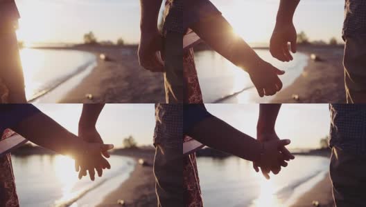 两个情人牵手。男人和女人的手在日落湖背景的细节剪影。夫妻信任，爱情和幸福的概念高清在线视频素材下载