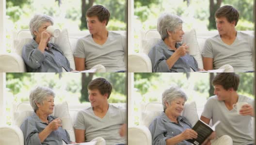 老奶奶坐着看书，孙子拿来了热饮高清在线视频素材下载