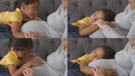 怀孕的母亲和女儿在沙发上休息高清在线视频素材下载