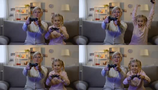 可爱的女孩和现代老奶奶在家里玩电子游戏，用操纵杆，休闲高清在线视频素材下载