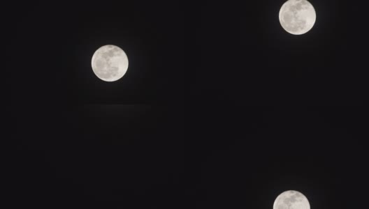 在漆黑的夜晚背景下，满月时刻的延时高清在线视频素材下载