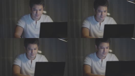 在家里工作的亚洲人深夜坐在电脑前。高清在线视频素材下载