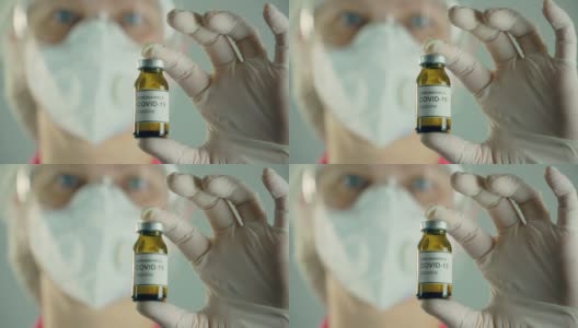 在全球流行期间，医学研究人员拿着装有抗冠状病毒现代疫苗的安瓿或瓶子，戴着面罩高清在线视频素材下载