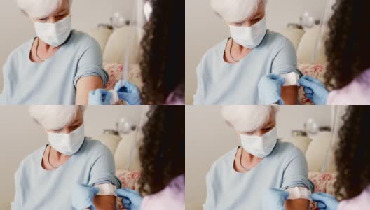 一名年轻女医生在家中为一名老年妇女接种疫苗的4k视频片段高清在线视频素材下载