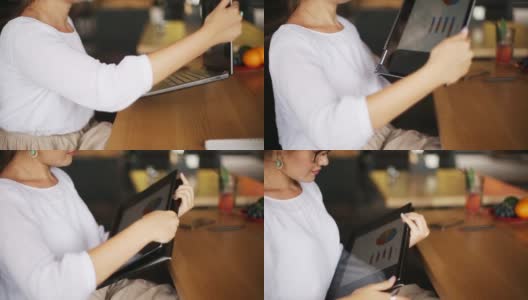 混合种族自由职业者转换笔记本电脑到平板电脑，而工作在咖啡馆。亚洲白人女商人与变压器笔记本。数码艺术家使用触摸屏二合一电脑高清在线视频素材下载