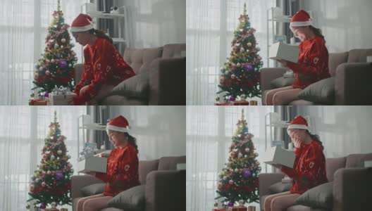 快乐的亚洲女人在圣诞节打开家里的礼品盒高清在线视频素材下载