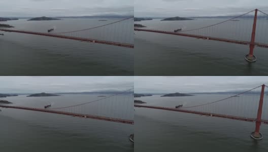 加利福尼亚州旧金山的金门大桥。多云的天空。恶魔岛和监狱，背景中的集装箱船。美国高清在线视频素材下载