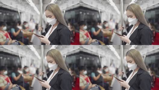 2019冠状病毒病大流行期间乘坐地铁时使用智能手机的女商人高清在线视频素材下载