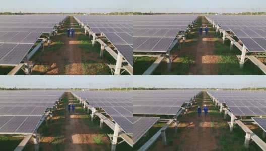 鸟瞰图，男男女女蓝领工人在检查大型太阳能农场、电力、太阳能产生的清洁能源后，走在太阳能电池板之间的小线上高清在线视频素材下载