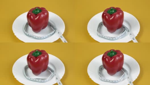 减肥的概念。一个红辣椒被包裹在一个卷尺里，卷尺延伸到框架外高清在线视频素材下载
