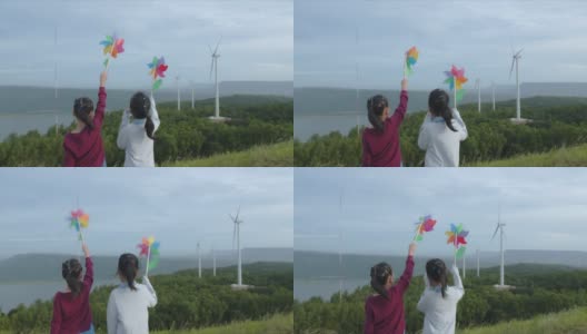 在风力发电场里，亚洲女孩们正在玩风力发电玩具高清在线视频素材下载