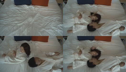 慢镜头FHD的幸福亚洲夫妇在爱躺在床上的浪漫时刻在豪华酒店的卧室，生活方式和休闲概念高清在线视频素材下载