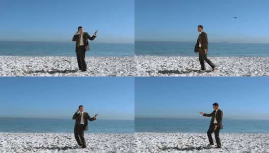 一个商人把他的手机扔向海滩的空中高清在线视频素材下载