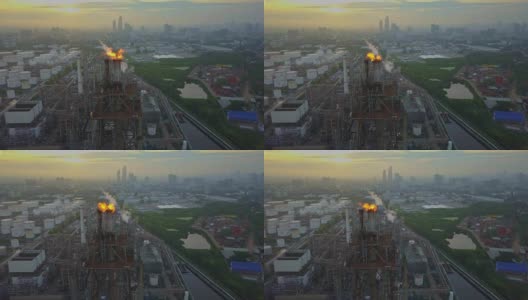 鸟瞰图的化学或炼油厂与燃烧的火炬在城市日出高清在线视频素材下载