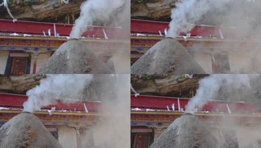 慢镜头:眼泪形状的燃烧器阴燃在前面的西藏寺院。高清在线视频素材下载