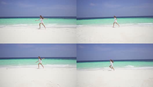 可爱的女孩在马尔代夫岛蔚蓝的海洋附近的白色沙滩上跑步。缓慢的运动。高清在线视频素材下载