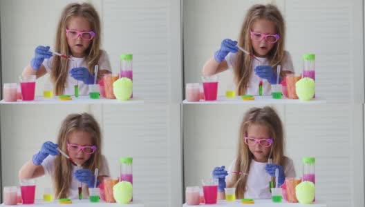 一个戴眼镜的小女孩正在玩自制的粉红色黏液。孩子们用手玩黏液玩具。使粘液。Copyspace。高清在线视频素材下载