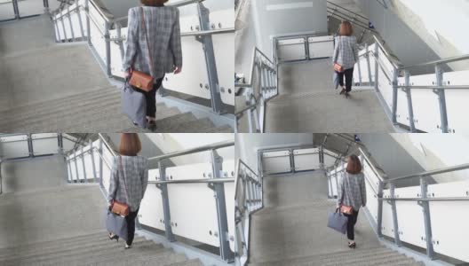 年轻的亚洲女子正从空铁站台走下楼梯高清在线视频素材下载
