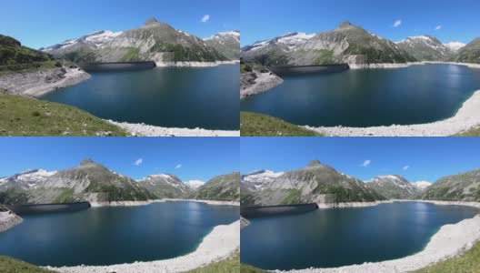 全景式的人工湖在科隆布雷因大坝在卡林西亚，奥地利。大坝被高山积雪覆盖的山峰包围着。陡峭的斜坡。这个湖是深蓝色的。自然能源高清在线视频素材下载