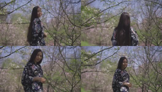 快乐苗条美丽的亚洲年轻女子在春天公园散步的背影转向镜头微笑。自信、快乐、放松的千禧一代在夏日的户外拍照。缓慢的运动。高清在线视频素材下载