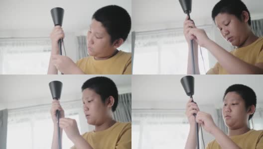 亚洲男孩在家组装从网上买的新电灯，男孩自己打结。高清在线视频素材下载