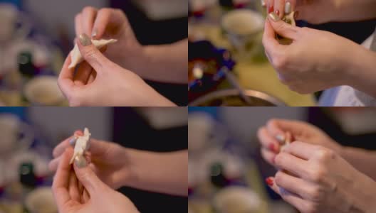 涂着指甲油的妇女在家里做传统的手工饺子。饺子馅有肉、蘑菇或土豆。每个饺子都必须仔细地粘好。高清在线视频素材下载