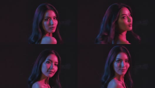 肖像拍摄的年轻调情可爱的亚洲女人调皮摆姿势的相机在粉红和蓝色霓虹灯在慢动作。高清在线视频素材下载