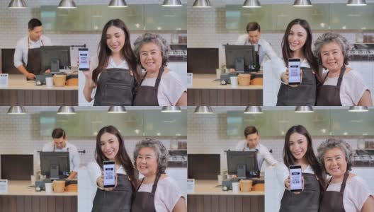 新冠肺炎疫情发生后，快乐的亚洲女儿和母亲在咖啡店使用二维码和移动设备付款，结束了封锁和隔离。成长中的小企业，科技，家族企业，多代家族，恩高清在线视频素材下载