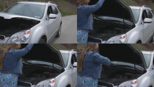 女司机在路边看她的SUV引擎盖下面高清在线视频素材下载