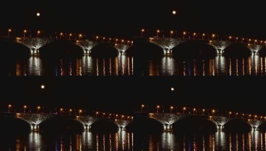 满月从桥上升起。延时。俄罗斯萨拉托夫和恩格斯之间的公路桥。伏尔加河。夜晚的车灯和街灯。4 k,超高清高清在线视频素材下载