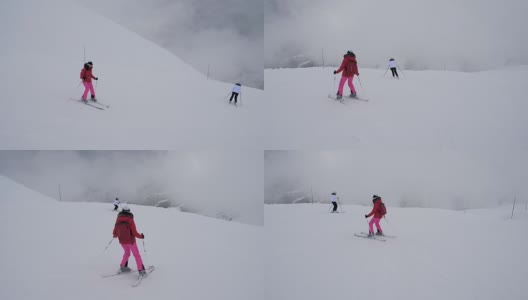 两名运动女滑雪者在冬季大雾中下山滑雪高清在线视频素材下载