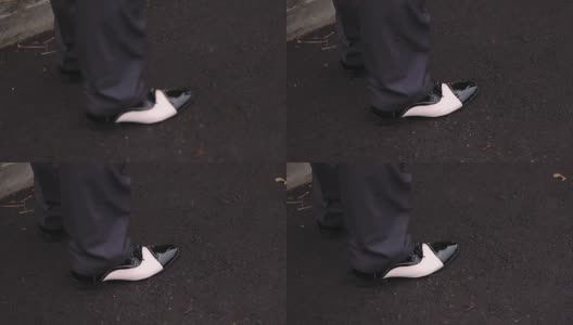 穿着黑色皮鞋站在柏油路面上的男性高清在线视频素材下载