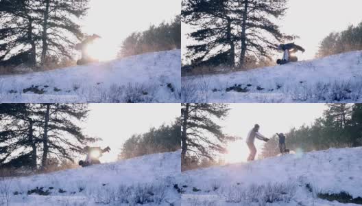 一家人一起在森林里玩，小男孩跑到了爸爸的手里，他们在慢镜头里落在了雪地上高清在线视频素材下载