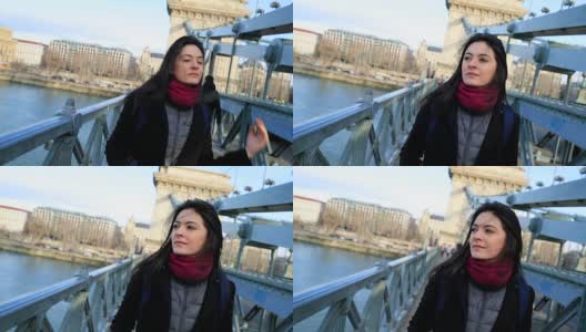 快乐的旅游女孩走在城市访问欧洲城镇的桥上。120帧慢动作的女人走路高清在线视频素材下载