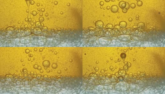 燃料，即金黄色的油，倒入实验室的玻璃容器中，释放出类似泡沫的气泡。高清在线视频素材下载