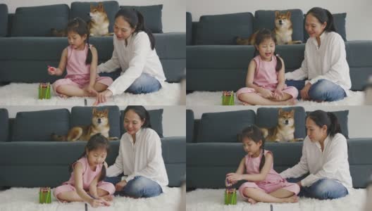 亚洲母亲和女儿和他们的狗一起画画。家庭室内休息。高清在线视频素材下载