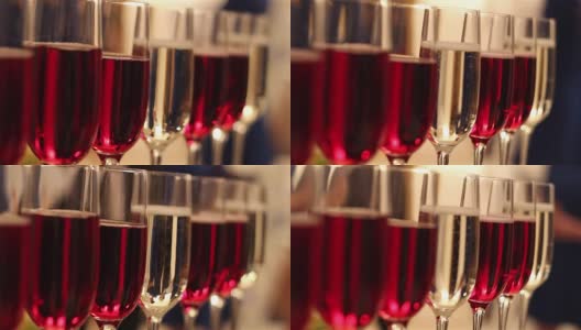 有酒精饮料的杯子，葡萄酒和香槟的杯子在自助餐桌上，红酒在玻璃杯里，香槟在玻璃杯旁边，在餐厅里有酒精的自助餐桌子，新年，圣诞节高清在线视频素材下载