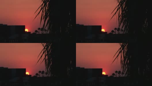 从建筑物后面窥视出来的夕阳。高清在线视频素材下载