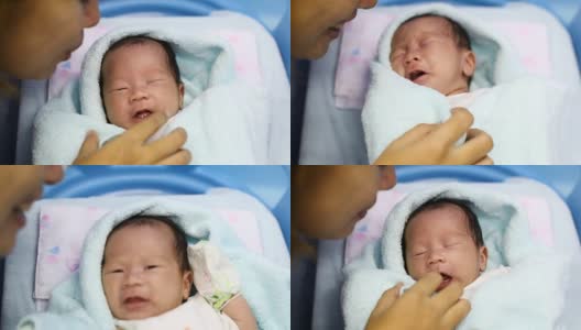 在医院的产房里，年轻的母亲抱着她刚出生的亚洲宝宝哭泣高清在线视频素材下载
