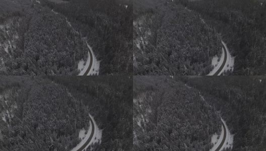 汽车行驶在雪地里的乡村道路上，无人机鸟瞰图高清在线视频素材下载