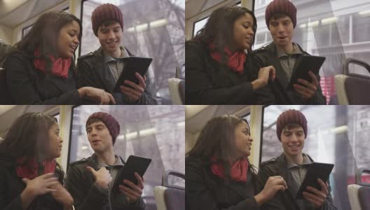 一对年轻情侣在火车上用平板电脑约会高清在线视频素材下载