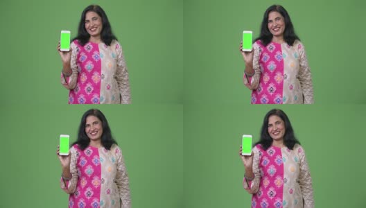 成熟快乐美丽的印度女人微笑着展示手机高清在线视频素材下载