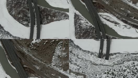 直接头顶无人机拍摄的汽车和车辆从70号州际公路隧道和横跨横跨科罗拉多河在科罗拉多州的落基山脉在一个下雪的冬天的一座桥高清在线视频素材下载