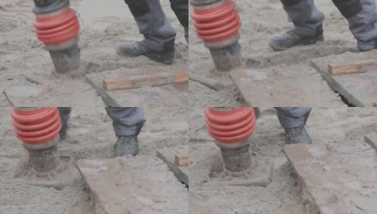 在建筑工地的工人，夯实夯，用夯实夯的工人。捣固土壤高清在线视频素材下载