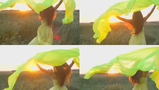 快乐年轻美丽的女人穿着黄色的衣服在麦田里奔跑在日落的夏天，自由健康的幸福理念。美女长着长发，自然在户外，举起双手徐莫太阳镜头耀光高清在线视频素材下载