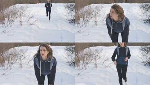春天或冬天的肖像，年轻的运动女孩在公园里跑步，穿着深色运动服在树上与雪的背景。健康的生活方式的概念。高清在线视频素材下载