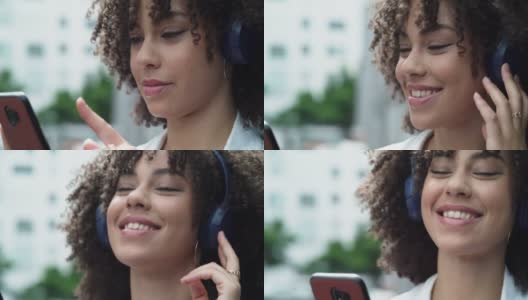 一个漂亮的年轻女子戴着耳机站在外面的4k视频片段高清在线视频素材下载