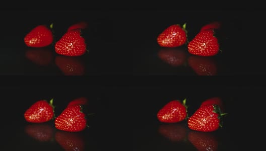 三颗草莓美丽地躺在黑色的桌子上，在一缕光线的背景下。高清高清在线视频素材下载